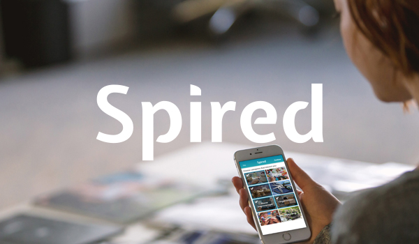 spired logo on background of woman looking at app